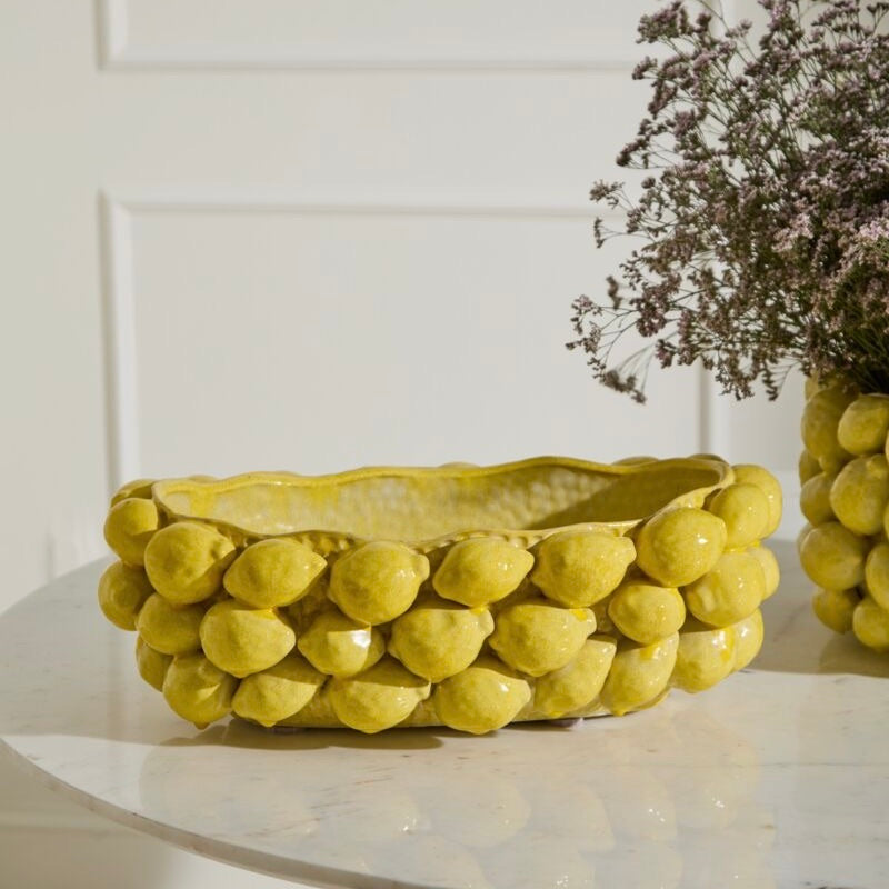 Yellow ceramic bowl with a textured surface on a white surface.