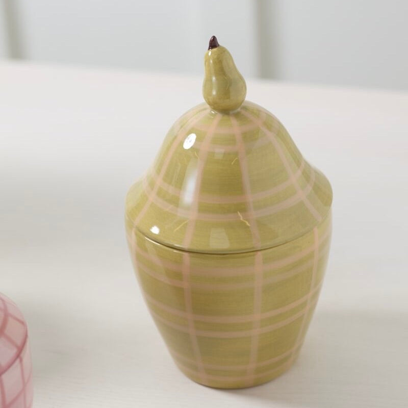 Ceramic jar with plaid pattern and pear-shaped handle on a white background