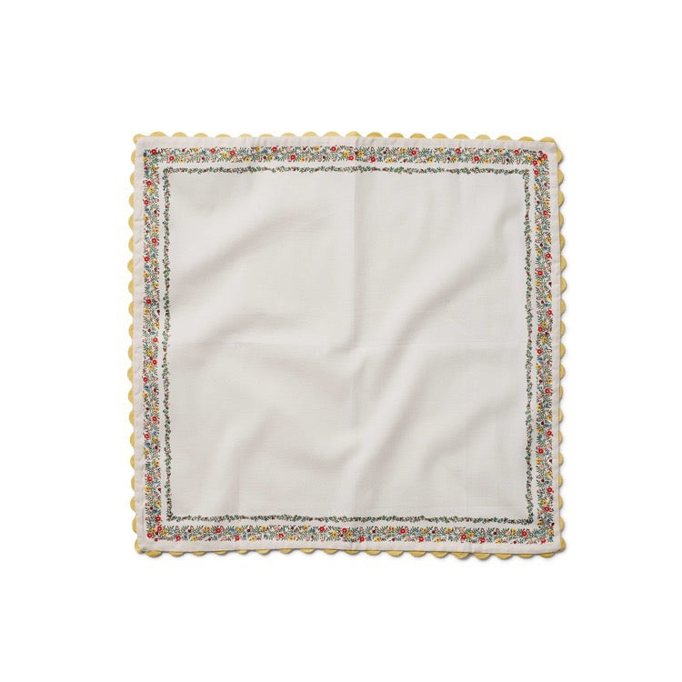 White napkin with decorative scalloped edge on a white background