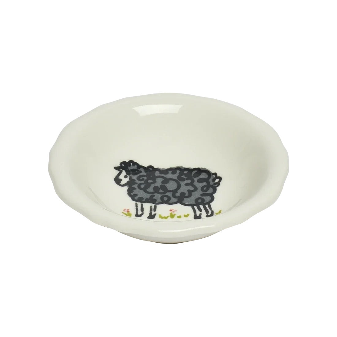 A small white ceramic bowl featuring a hand-painted black sheep illustration with tiny yellow flowers along the bottom edge, set against a plain white background.