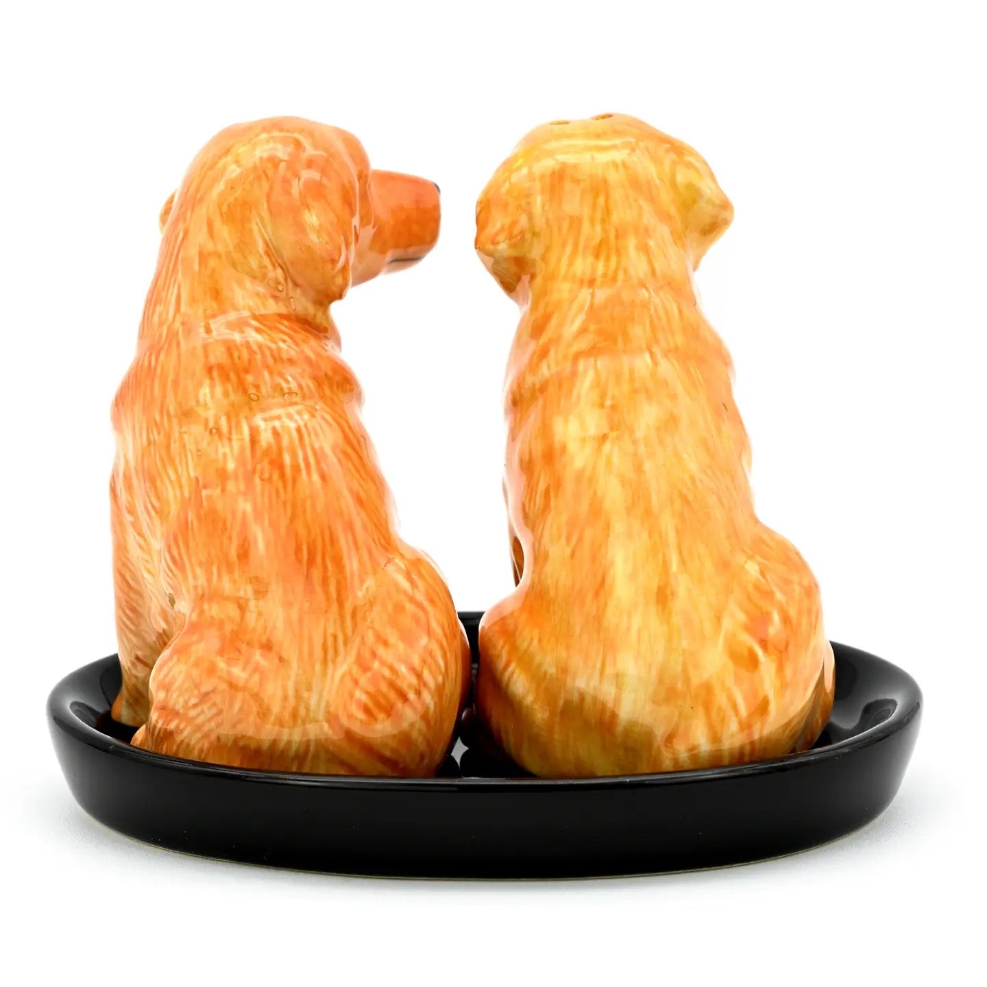 Two dog-shaped salt and pepper shakers on a black base with a white background