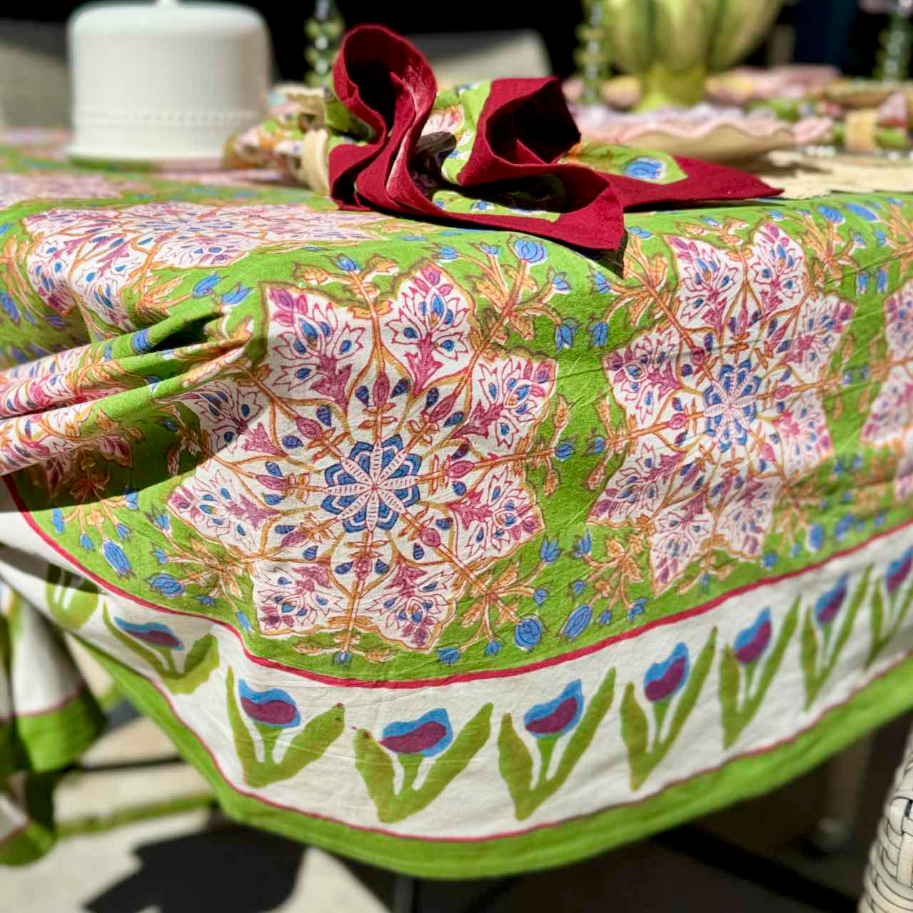 Colorful floral-patterned tablecloth on a table with a decorative bow.