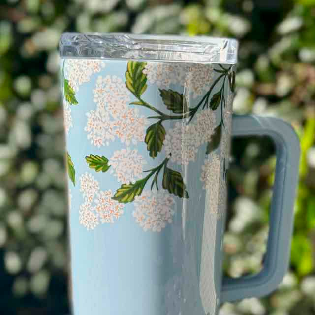 Tumbler with floral design on a light blue background