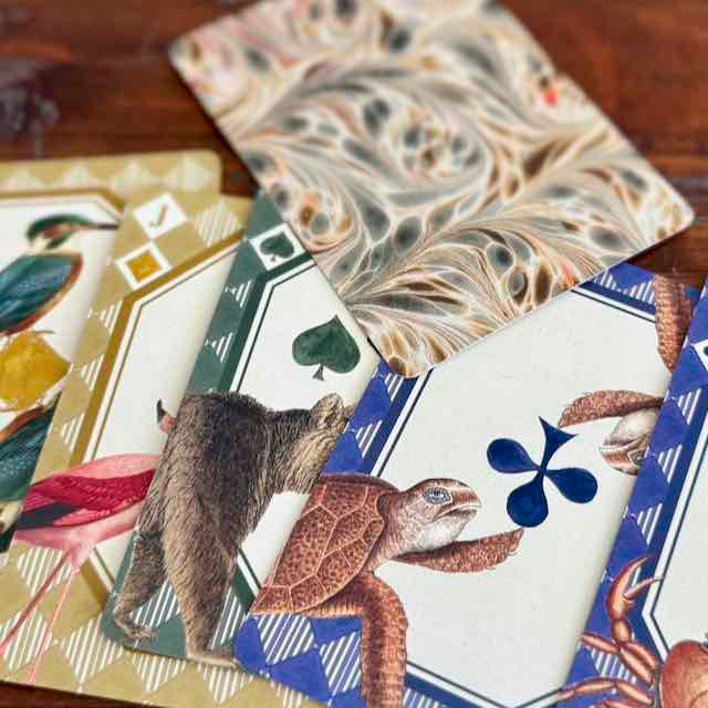 Playing cards with animal illustrations on a wooden surface