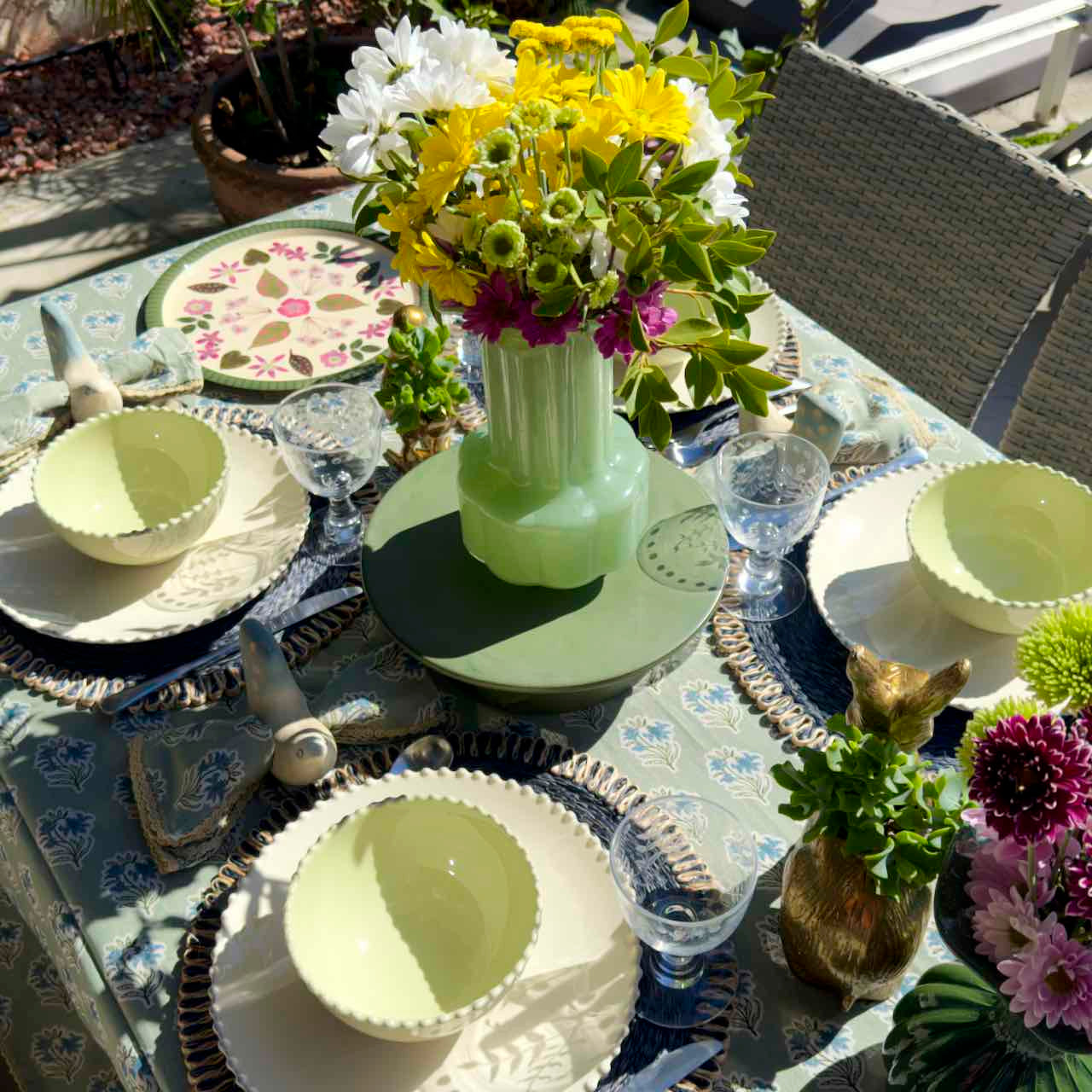 Decorative table setting with floral arrangements and place settings on a patio table.
