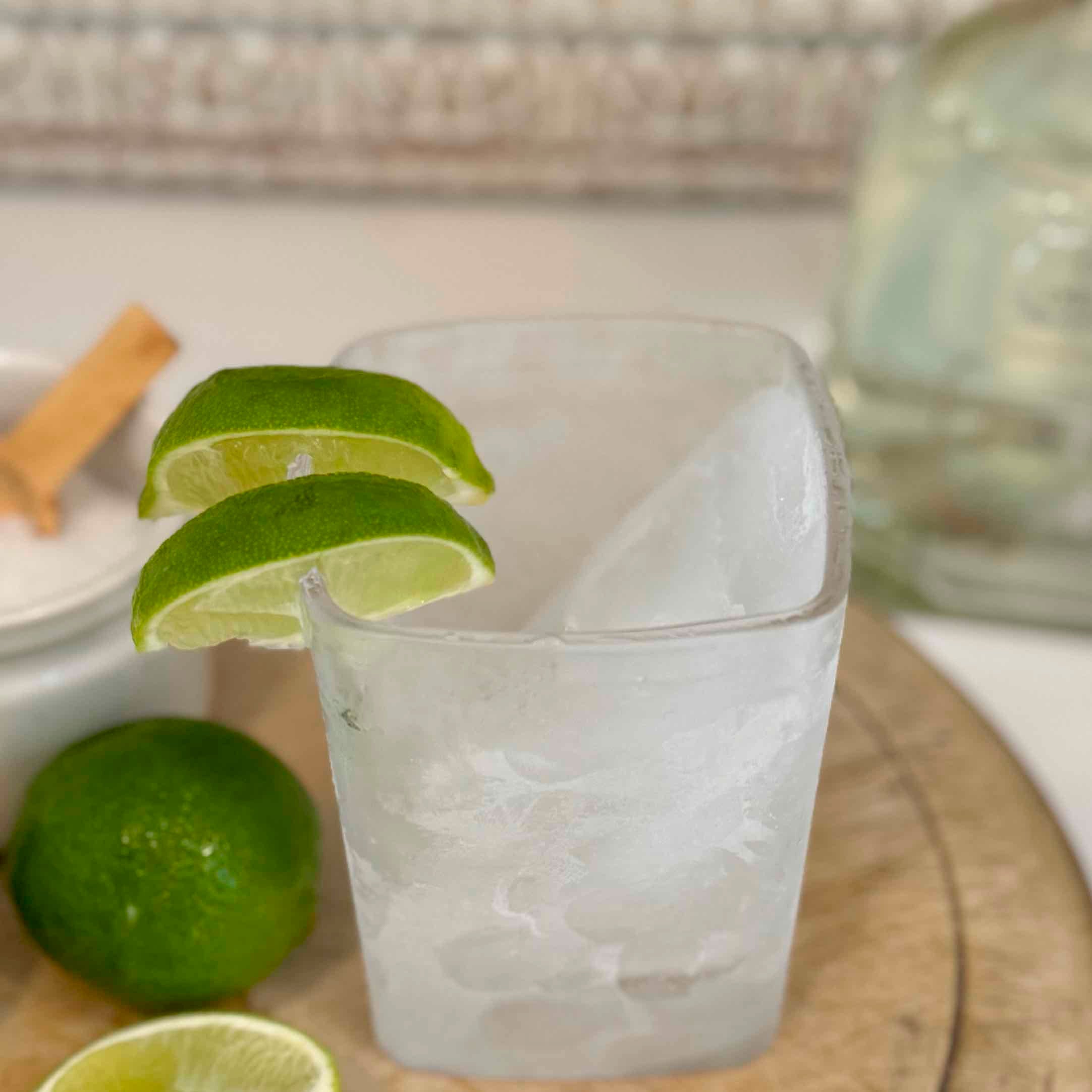 Frosted glass with lime wedges on a wooden surface