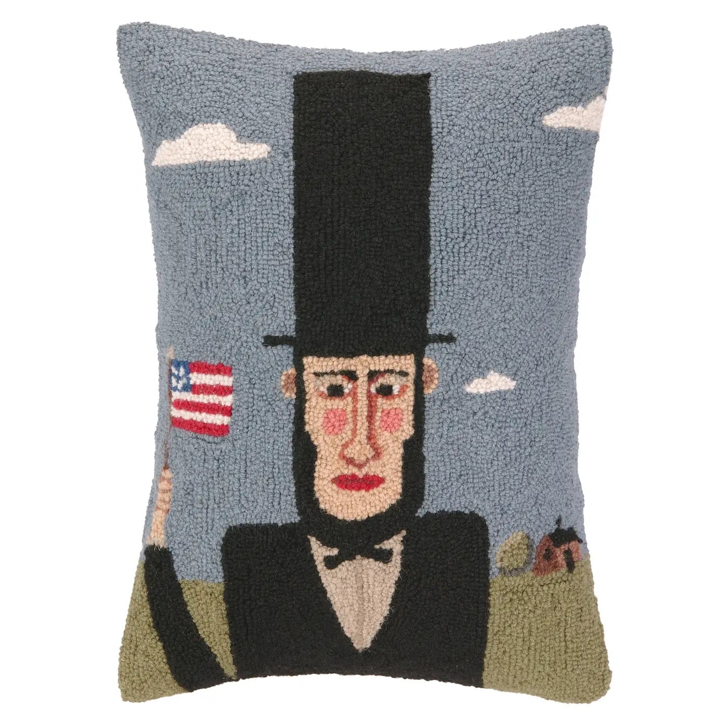 Decorative pillow with a portrait of a man in a top hat and suit, holding an American flag, against a blue sky with clouds.