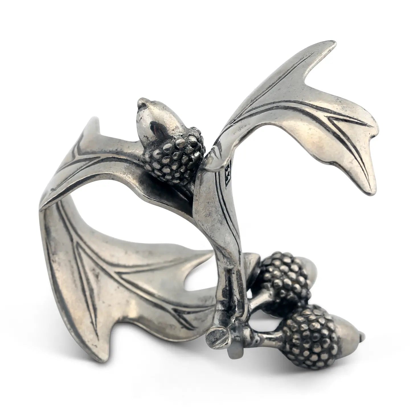 Silver ring with acorn design on a white background