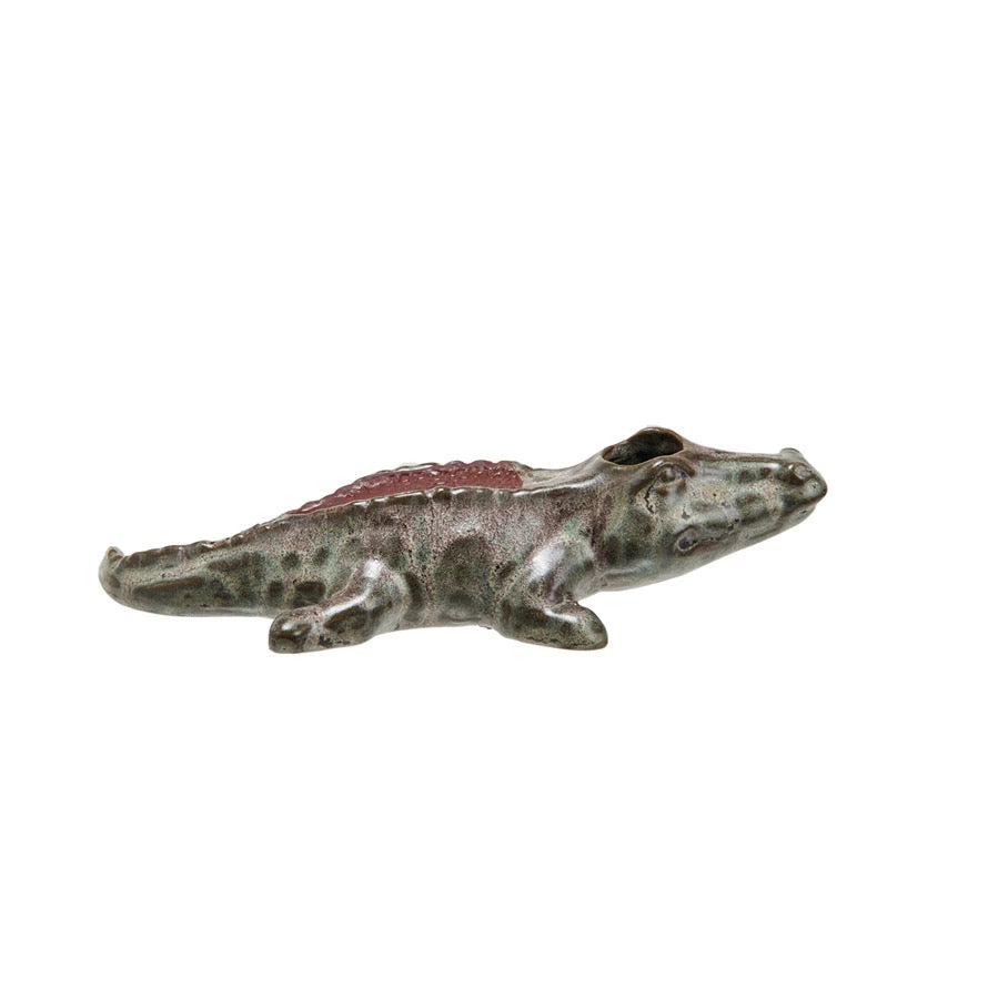 Small ceramic alligator figurine on a white background