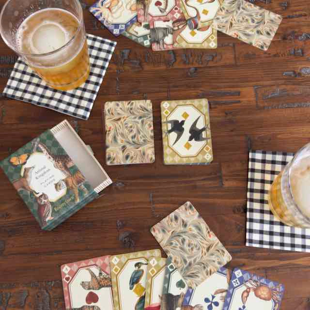 Decorative coasters with artistic designs on a wooden table with drinks.