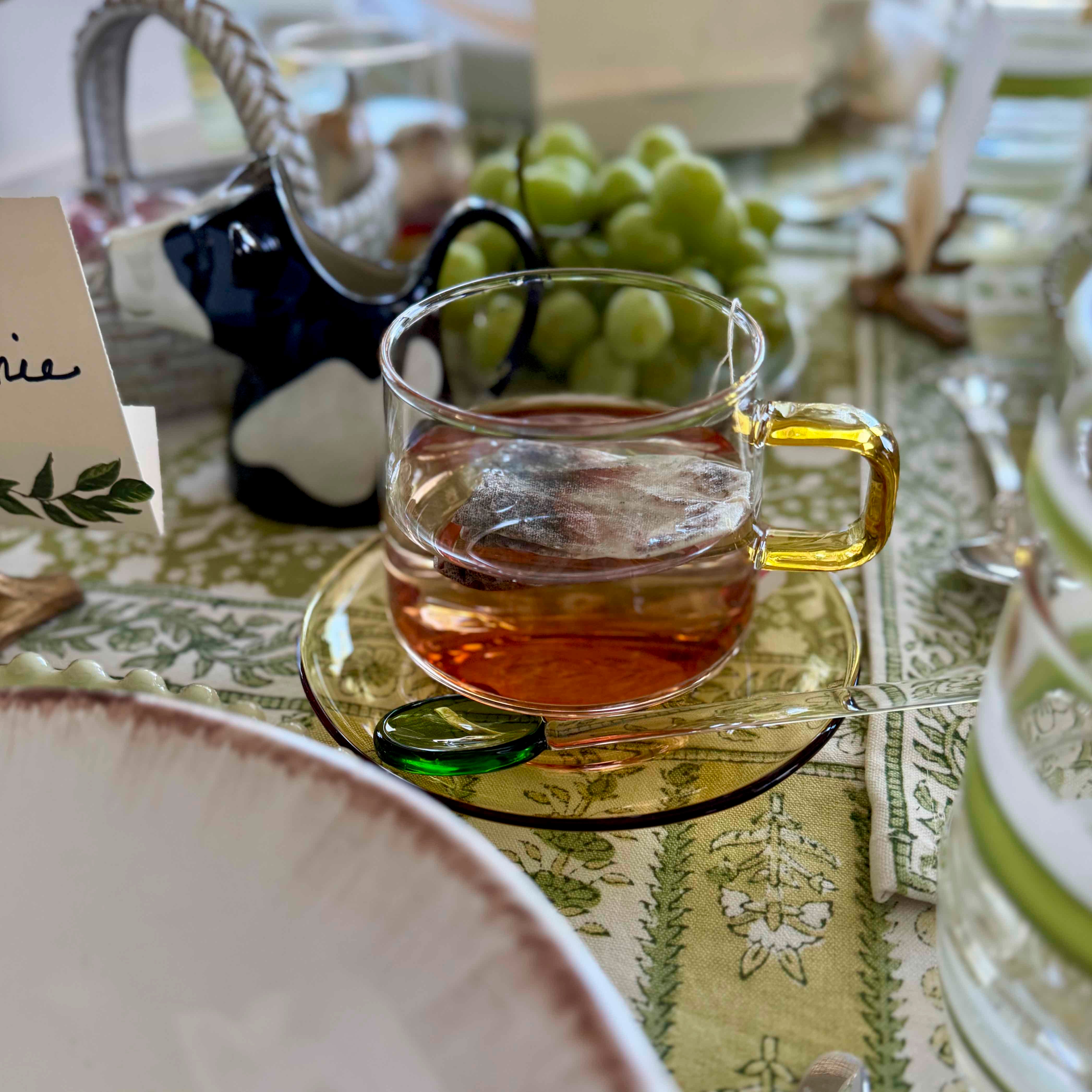 Clear glass mug with amber liquid on a patterned tablecloth