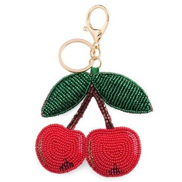 Keychain shaped like a beaded cherry with a green leaf on a white background