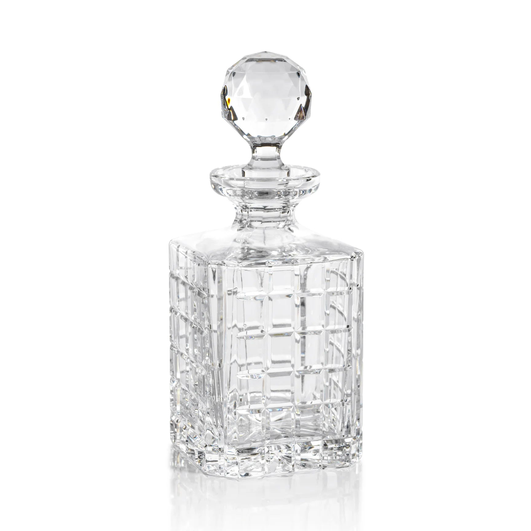 A clear crystal brandy decanter with a rounded top and a long, slender body. It features intricate cut patterns on its surface.