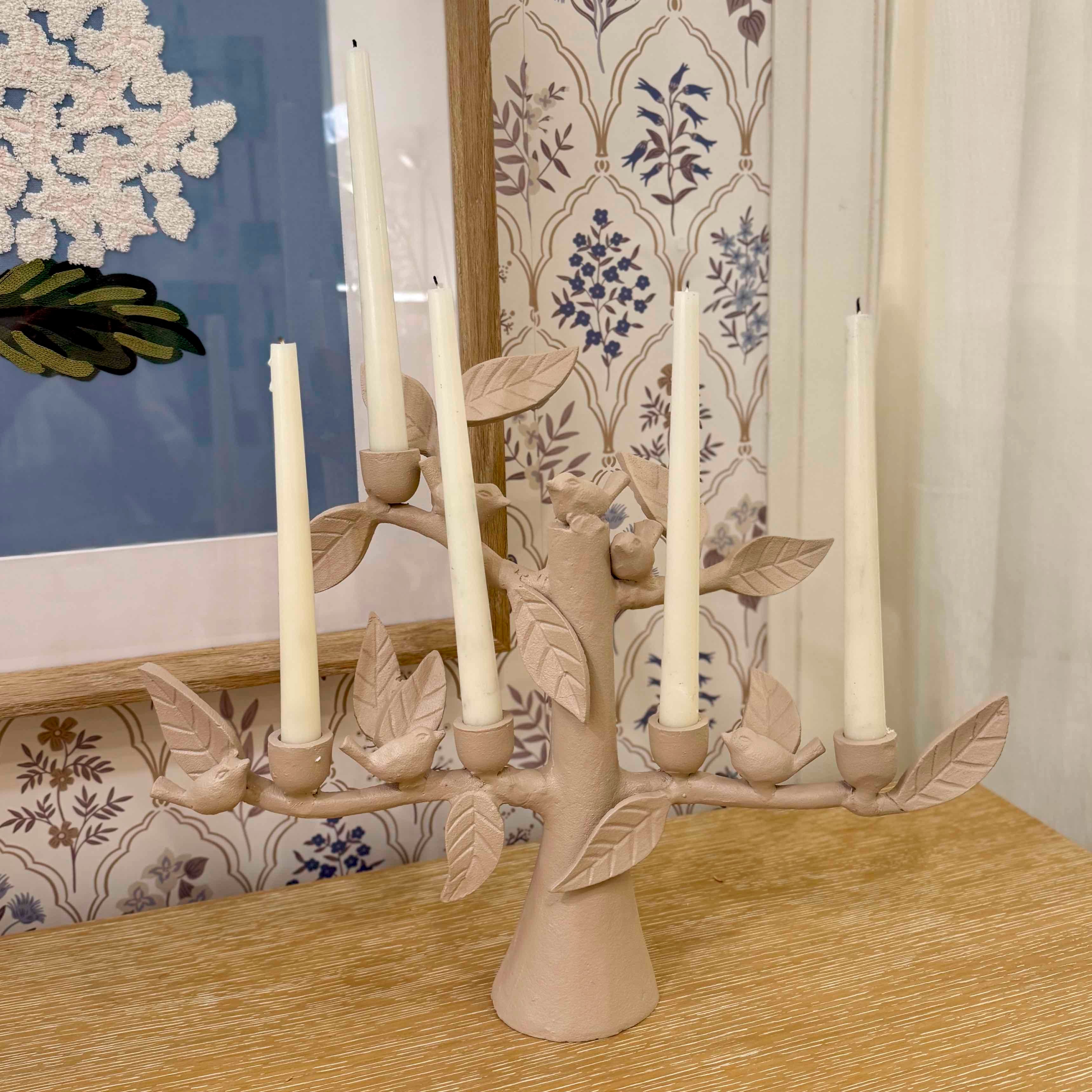 Candle holder with leaves and candles on a wooden surface