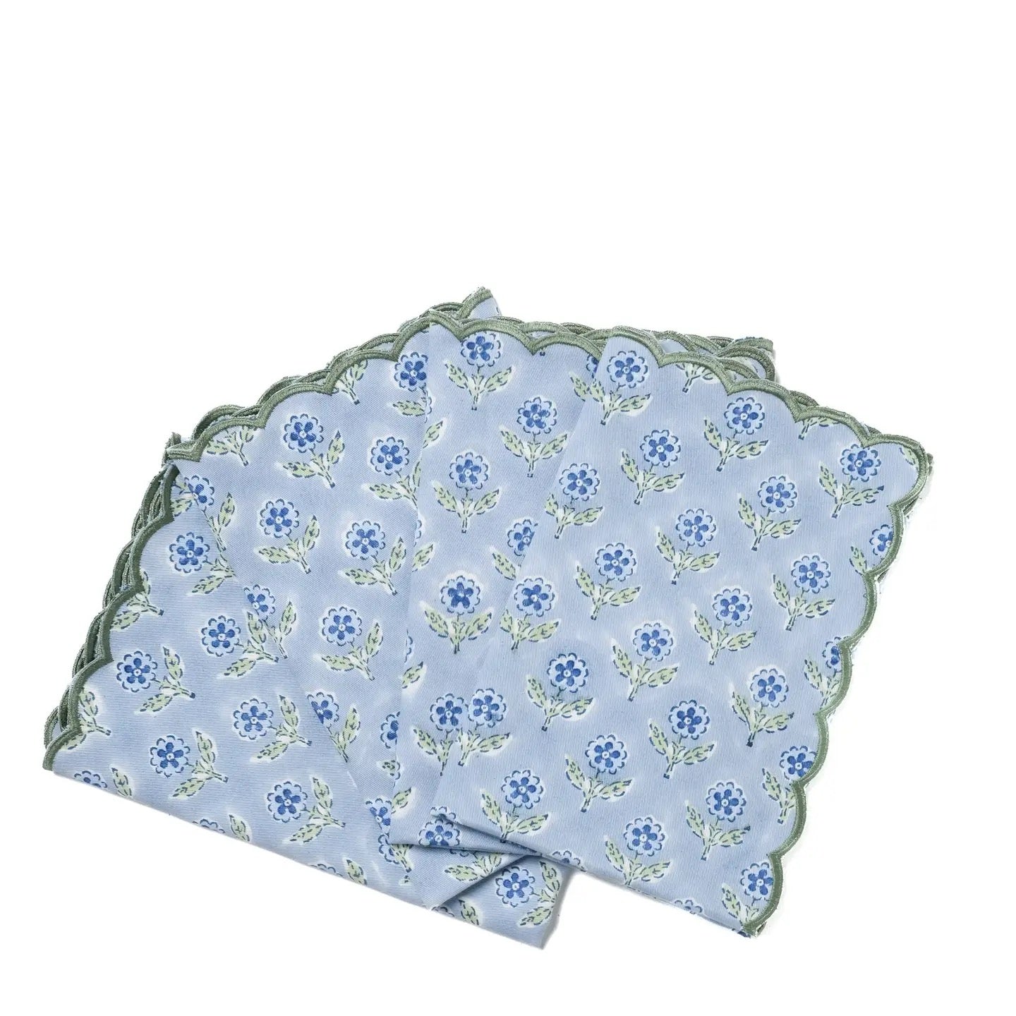 Set of three floral-patterned napkins with scalloped edges on a white background