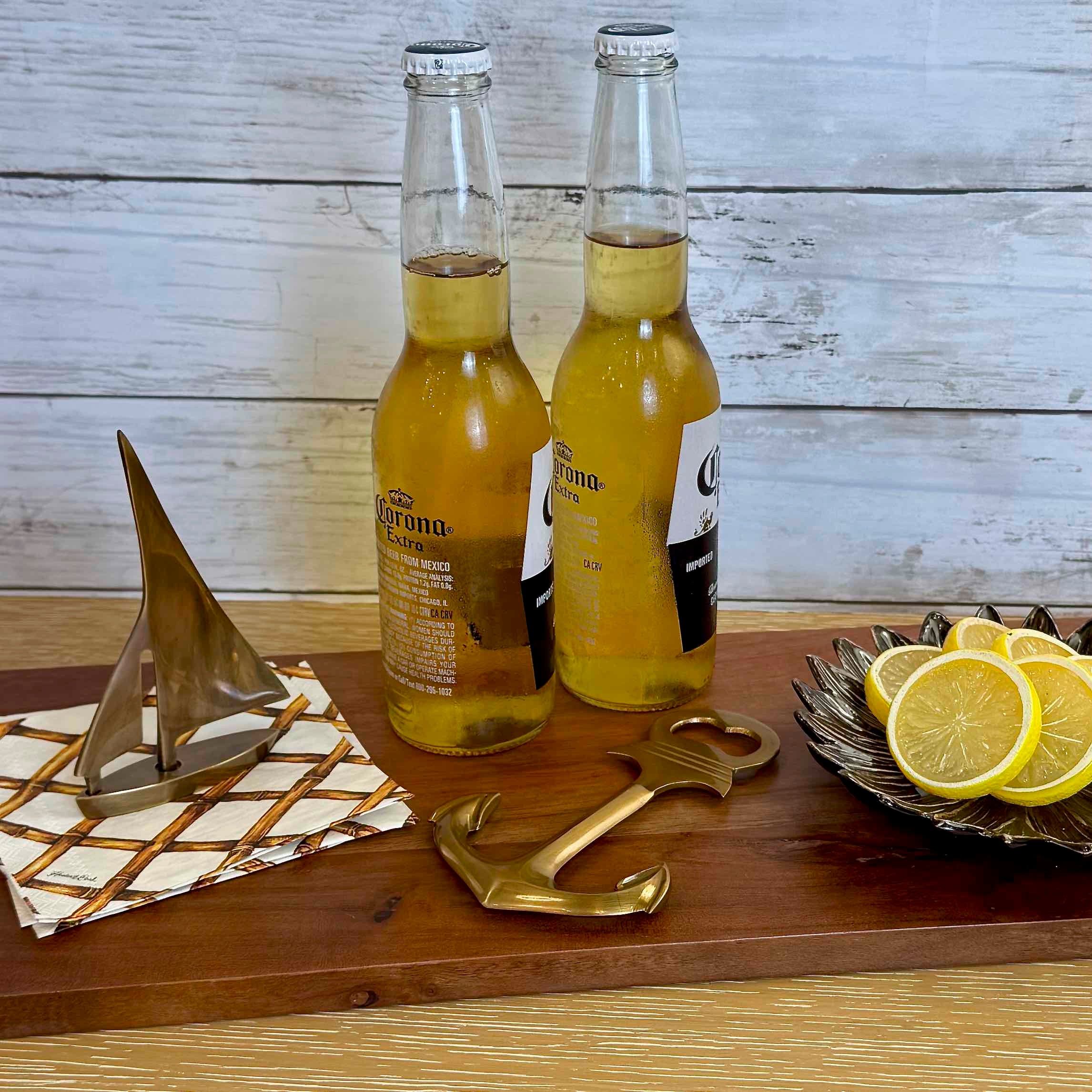 Two bottles of Corona beer on a wooden surface with lemon slices and decorative items.