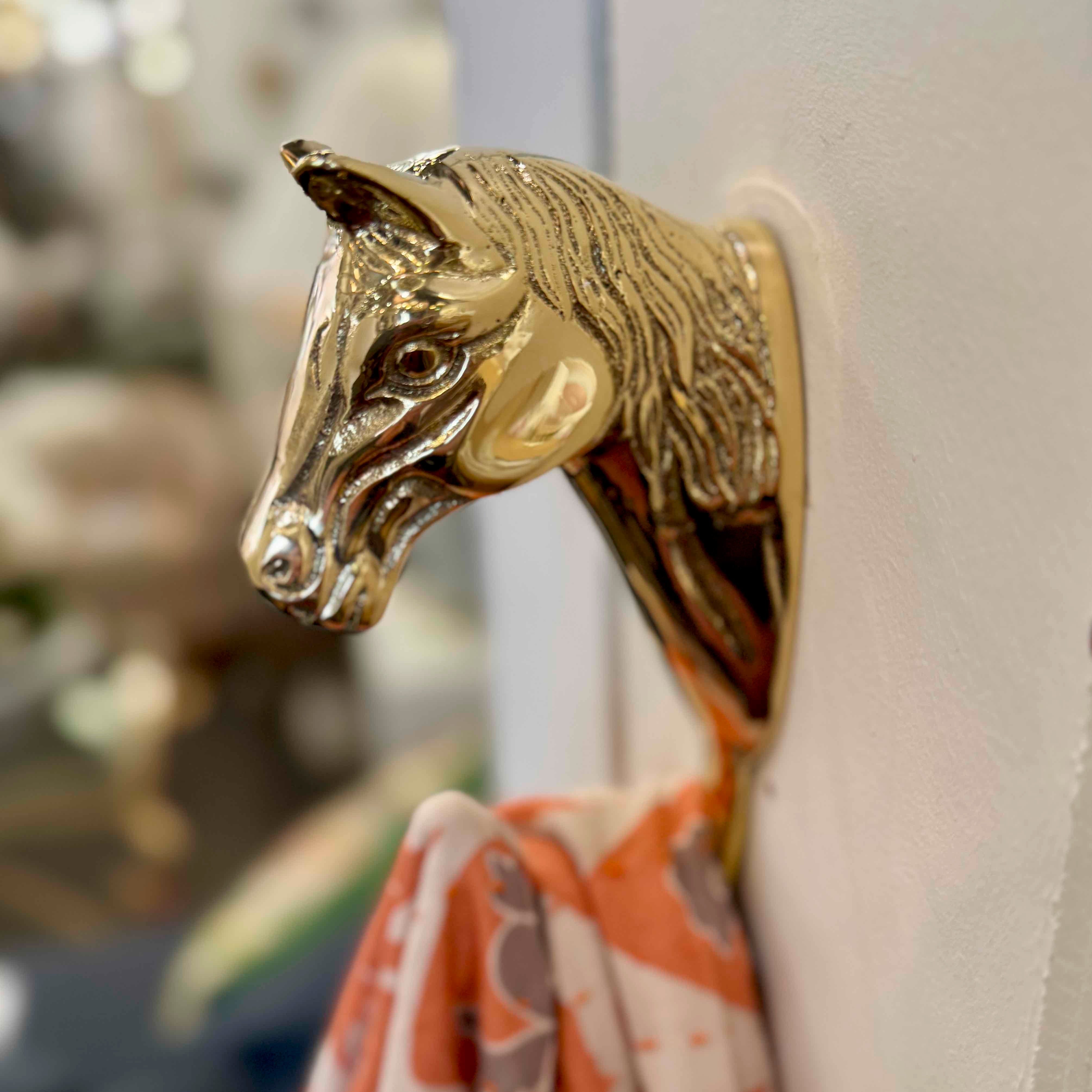 Gold bull head wall hook on a white wall with a blurred background