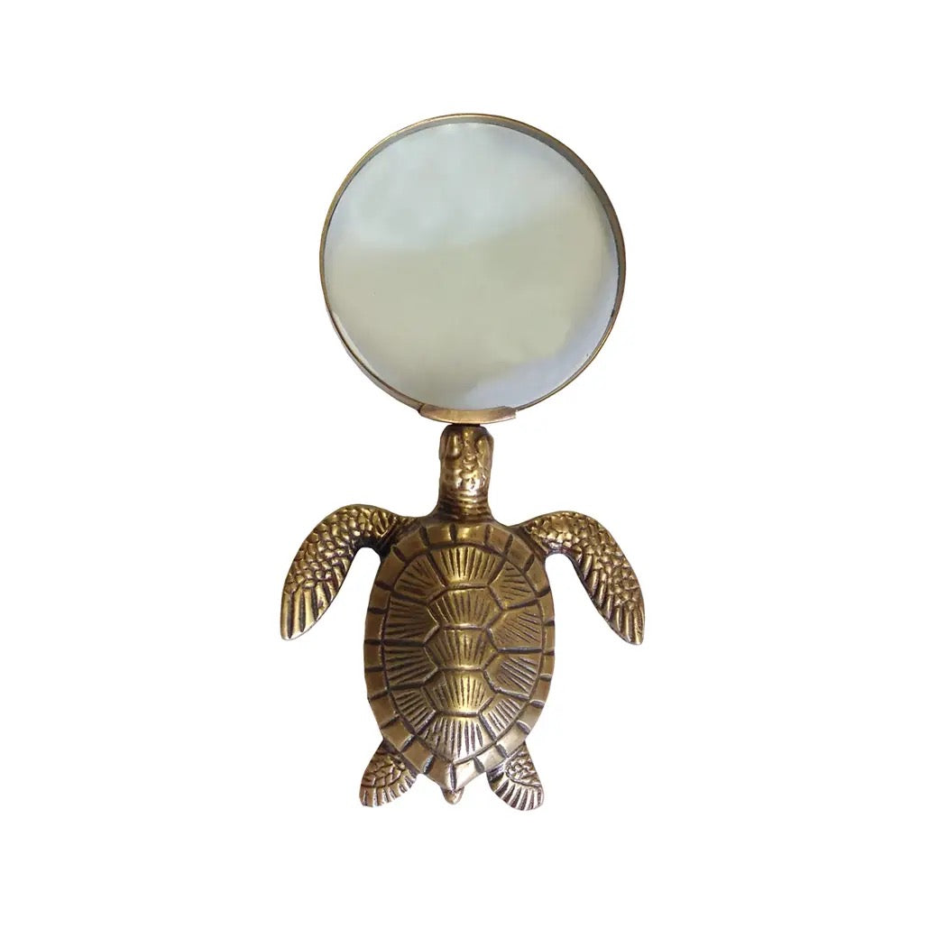 Gold turtle-shaped magnifying glass on a white background