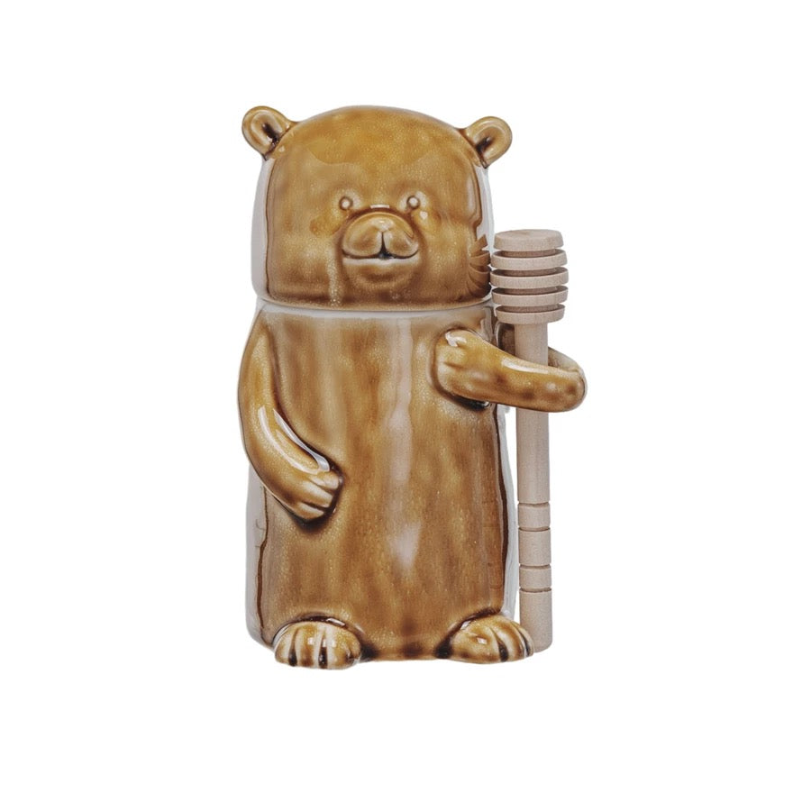 Bear-shaped container holding honey on a white background