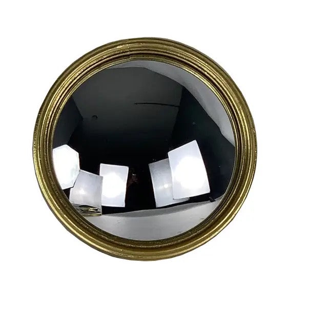 Round convex mirror with gold frame on a white background