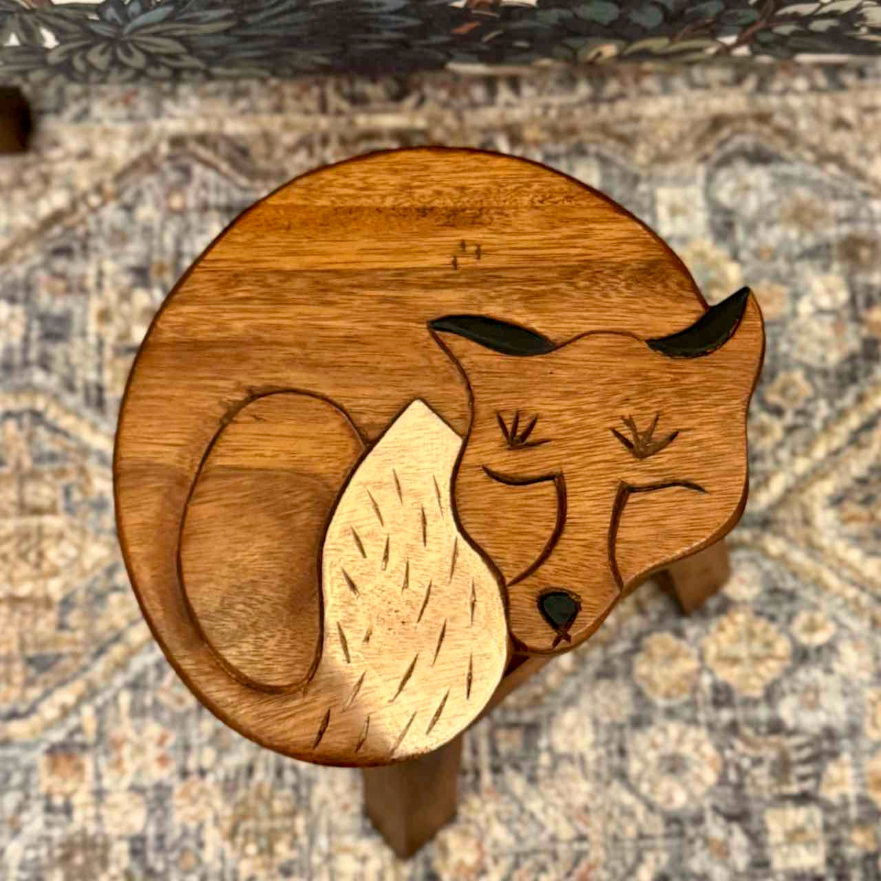 Wooden fox figurine on a patterned surface