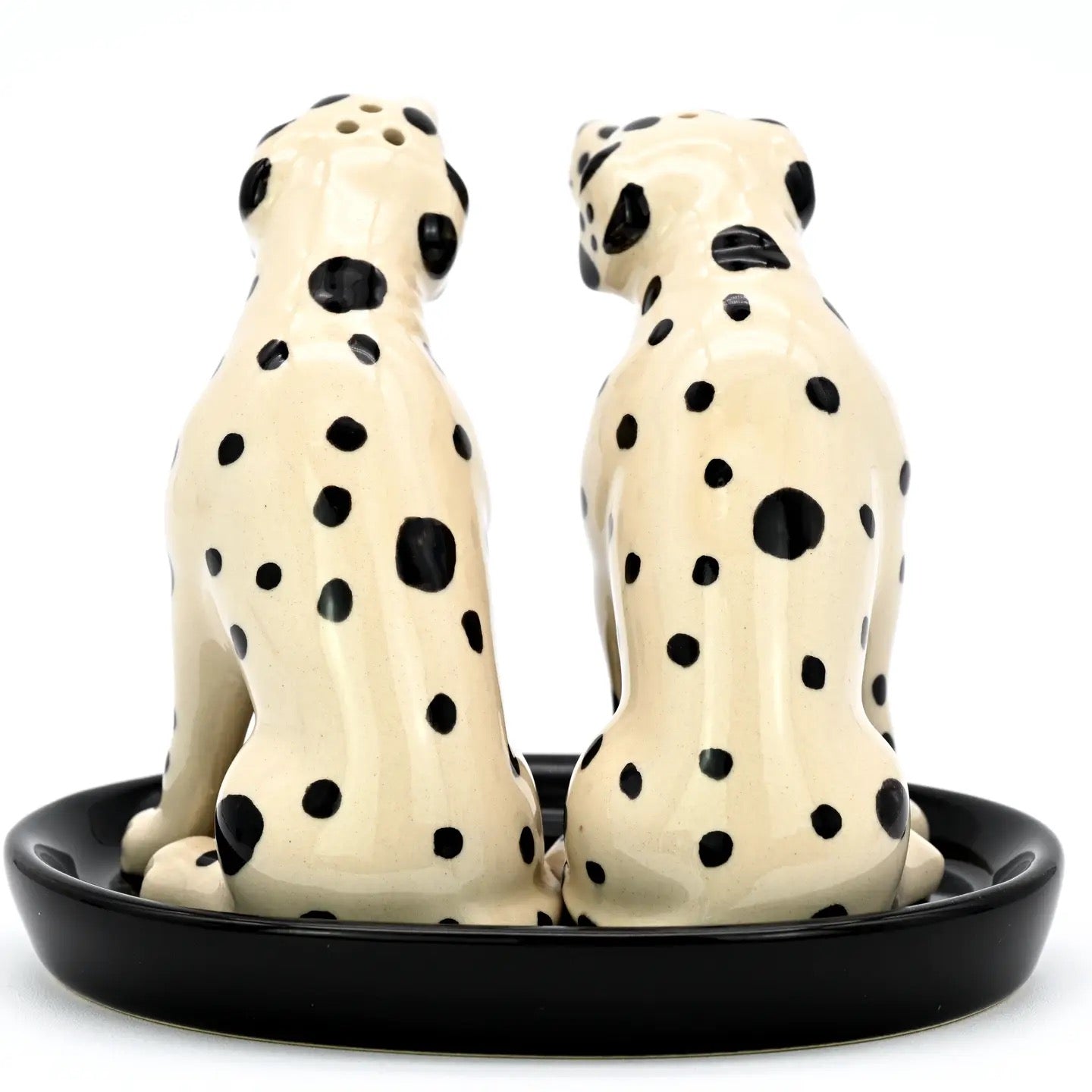 Two ceramic Dalmatian dog salt and pepper shakers on a black base.