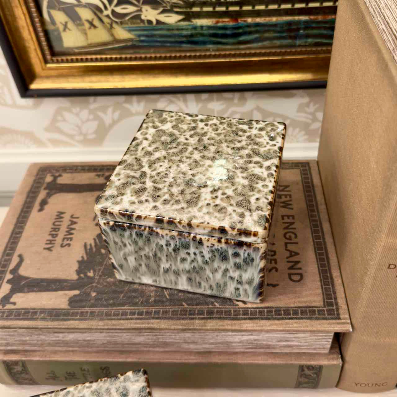 Decorative box with a textured surface on top of vintage books