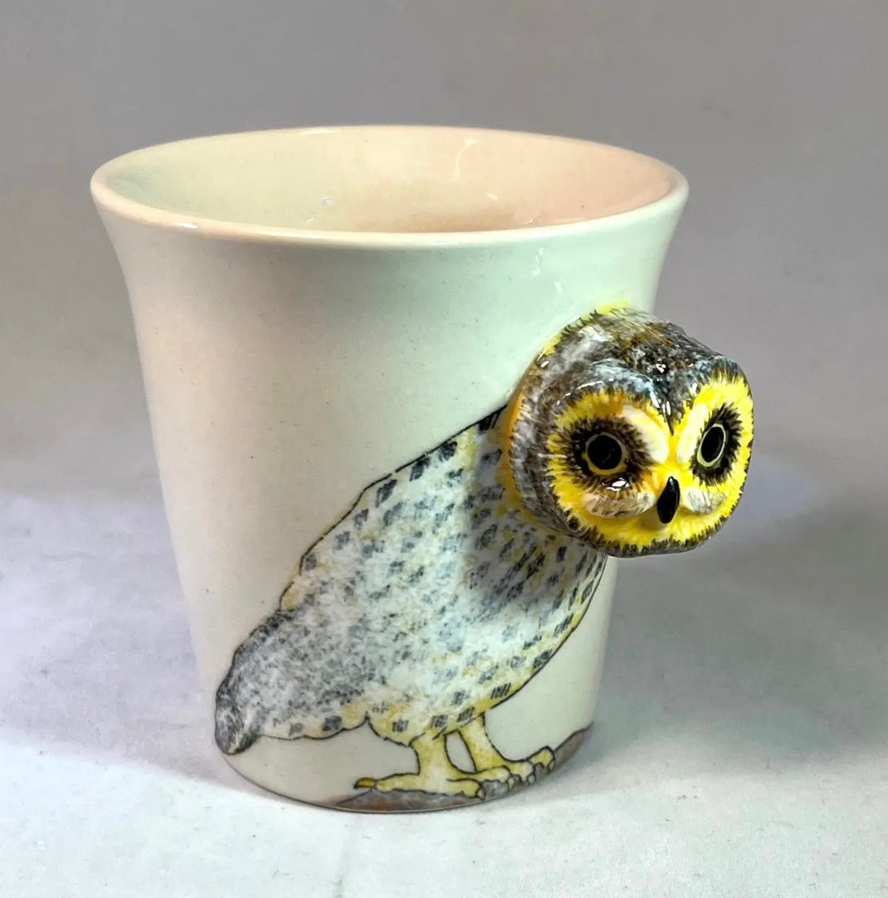 Ceramic cup with an owl design on a gray background