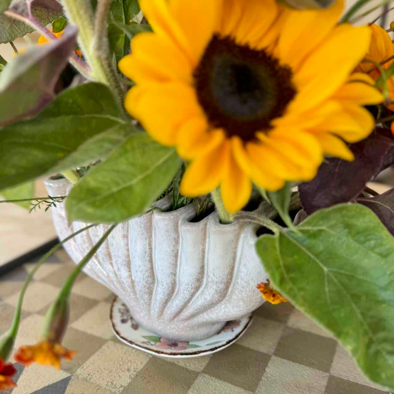 Sunflower in a decorative pot on a checkered tablecloth