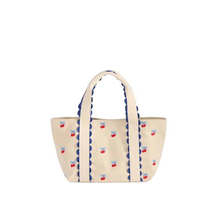 Beige tote bag with blue scalloped edge and red cherry designs on a white background