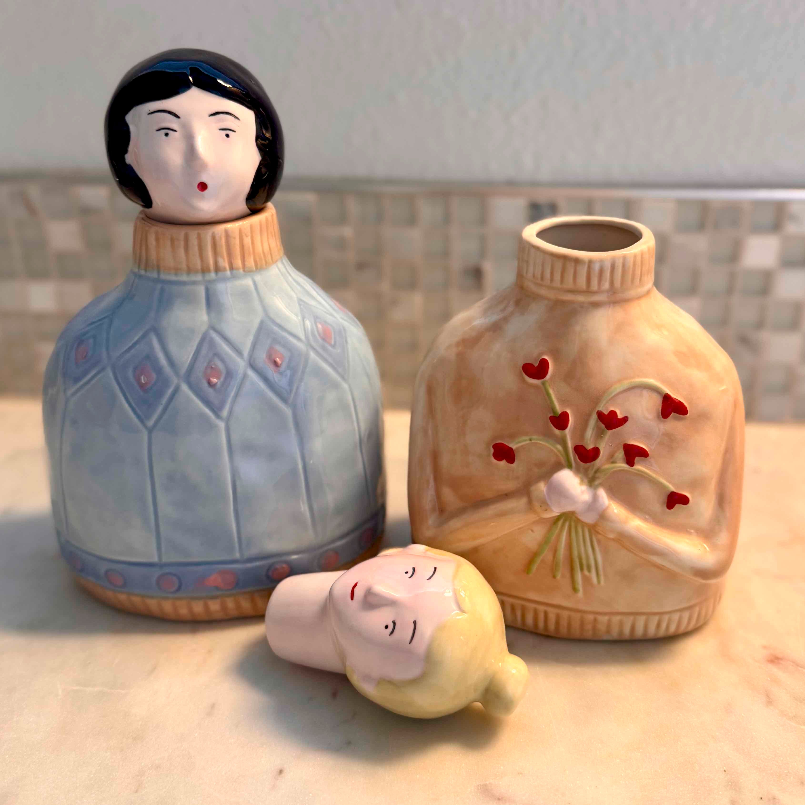 Three ceramic figures on a surface with a neutral background