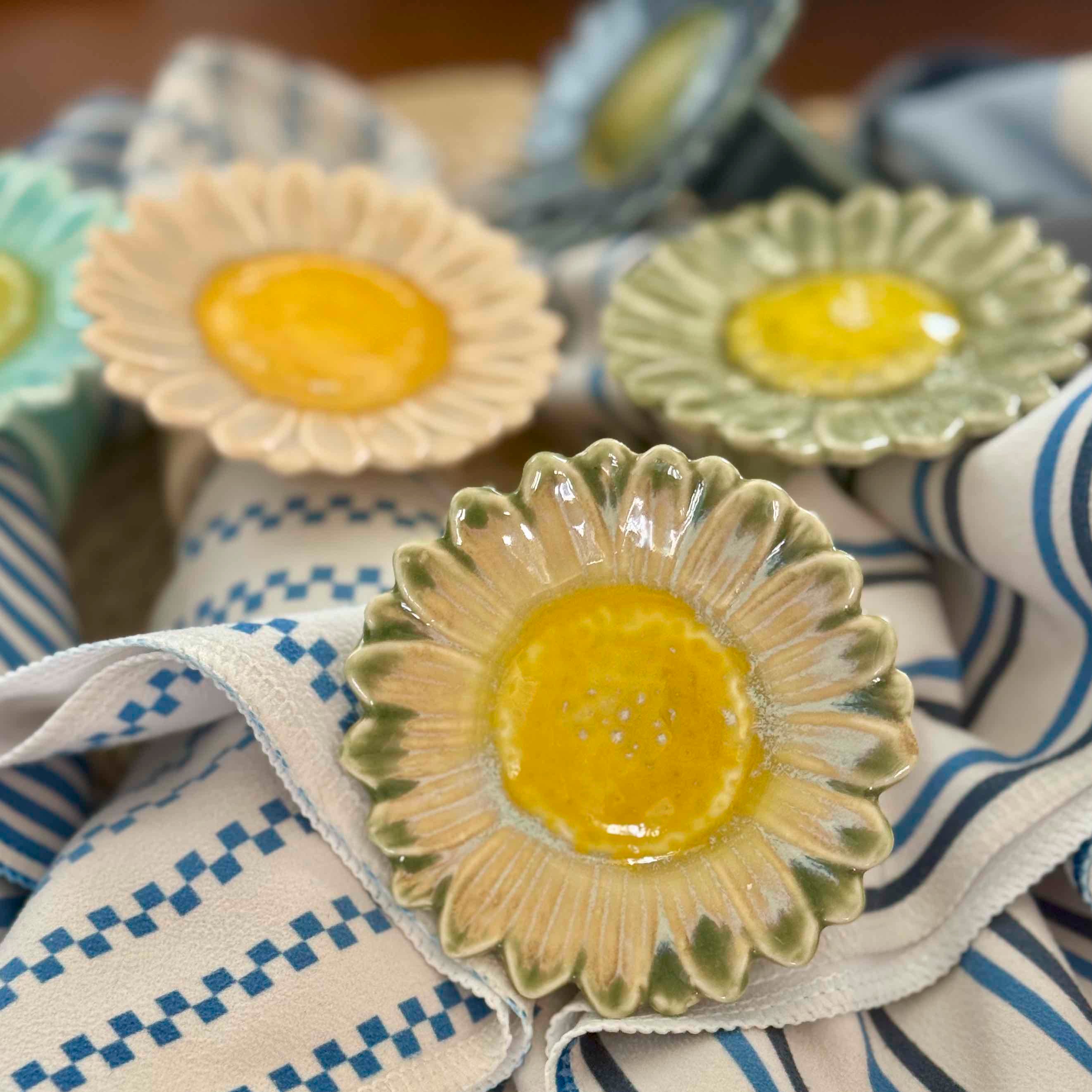 Ceramic plates with yellow centers and green edges on a striped fabric background
