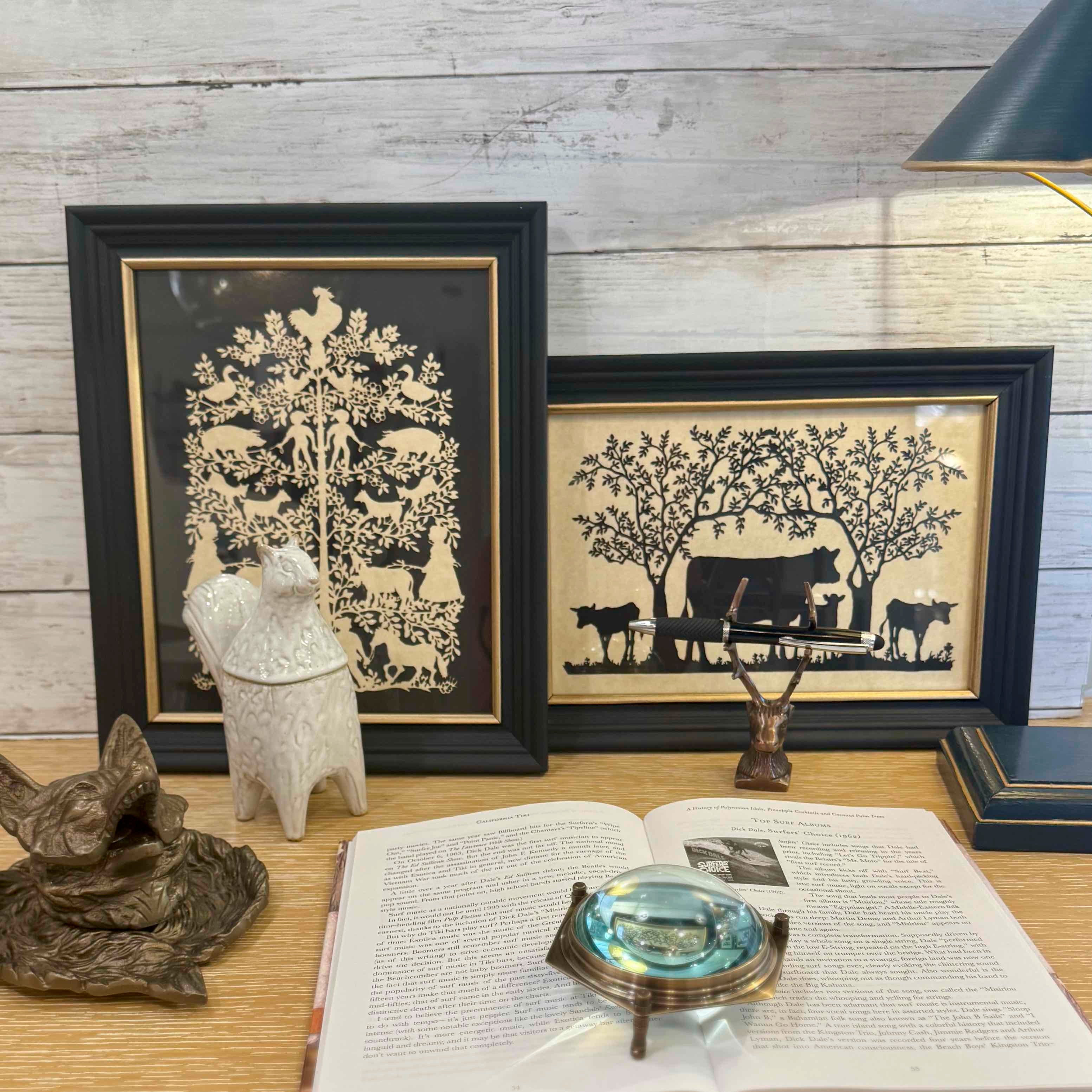 Framed silhouettes of animals on a wooden surface with decorative items.