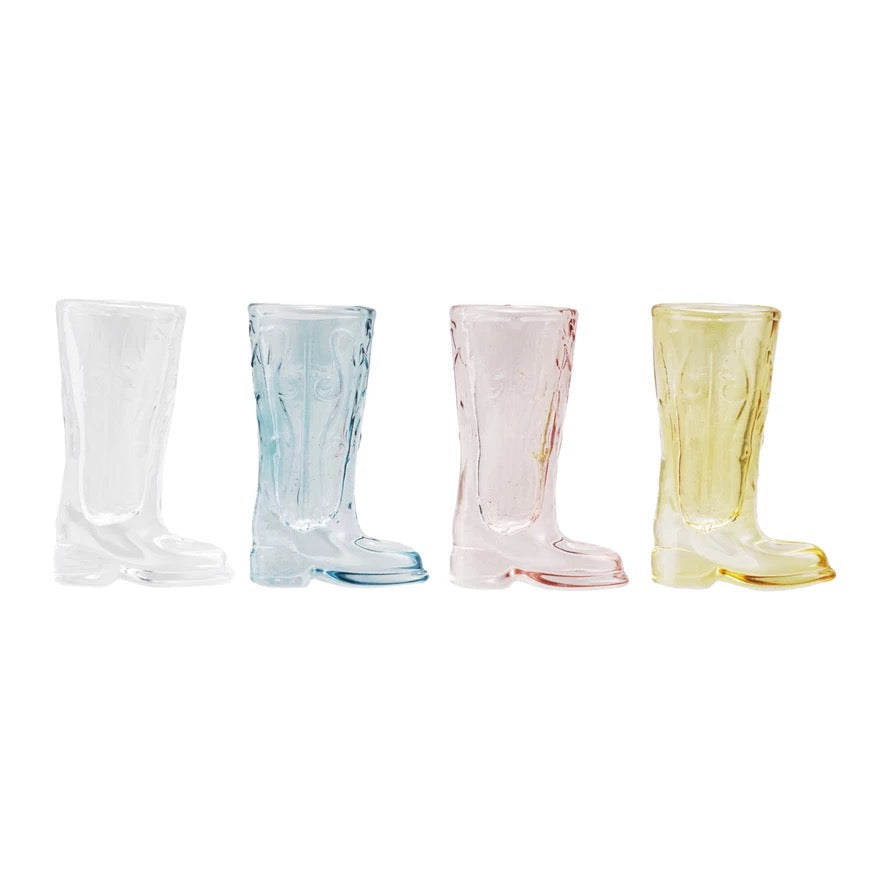 Four transparent glass boots in different colors on a white background