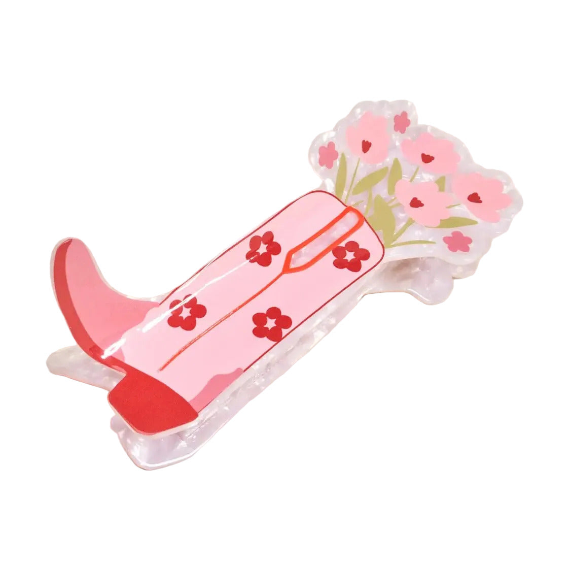 A pink boot-shaped acrylic pin with red floral patterns and a matching pink flower cluster, displayed on a light beige background.