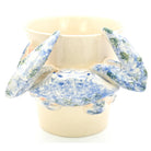 Ceramic crab with blue and white speckled pattern on a beige background