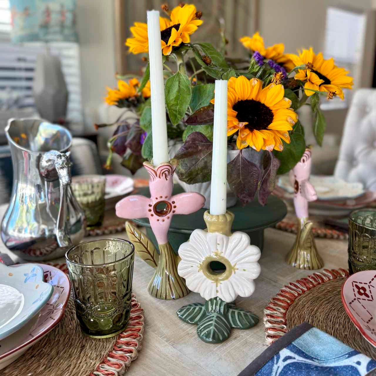 Decorative table setting with sunflowers, candles, and ornate candle holders.