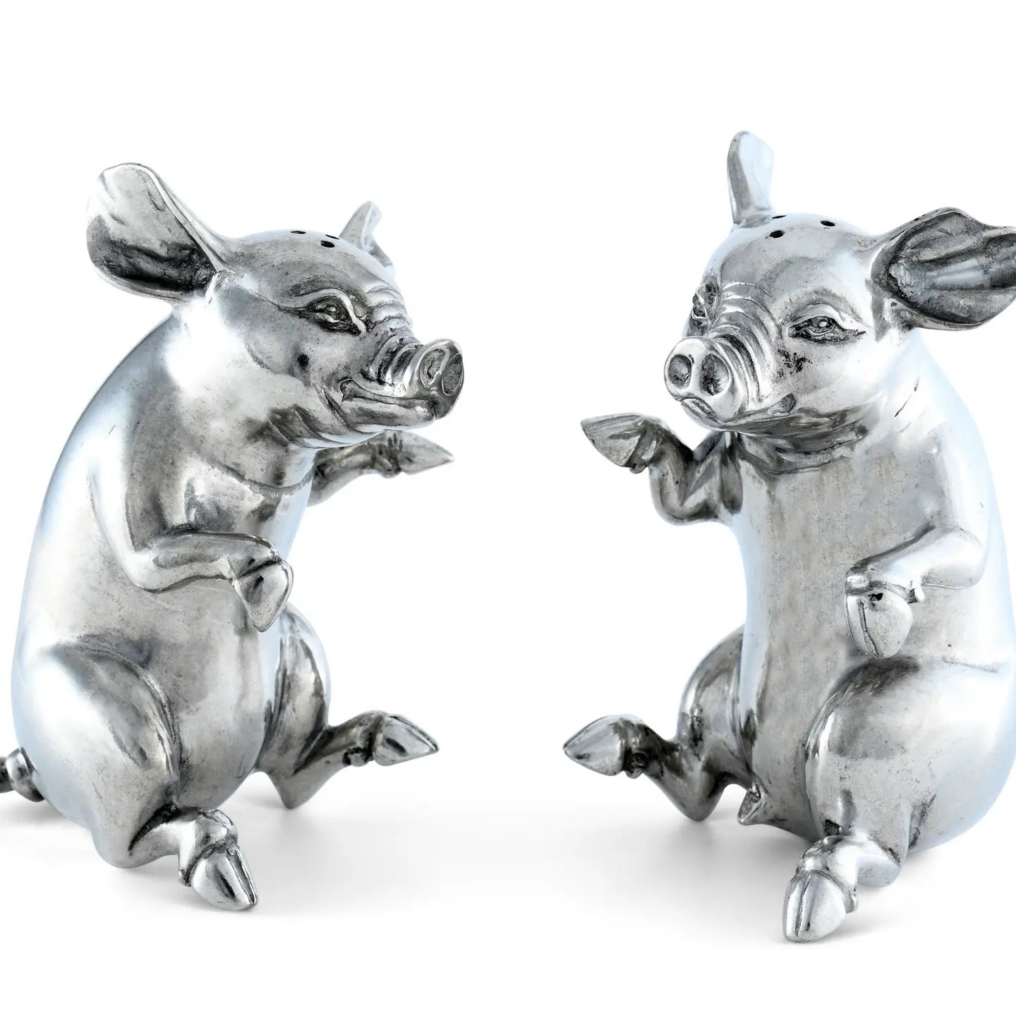 Two silver pig figurines on a white background