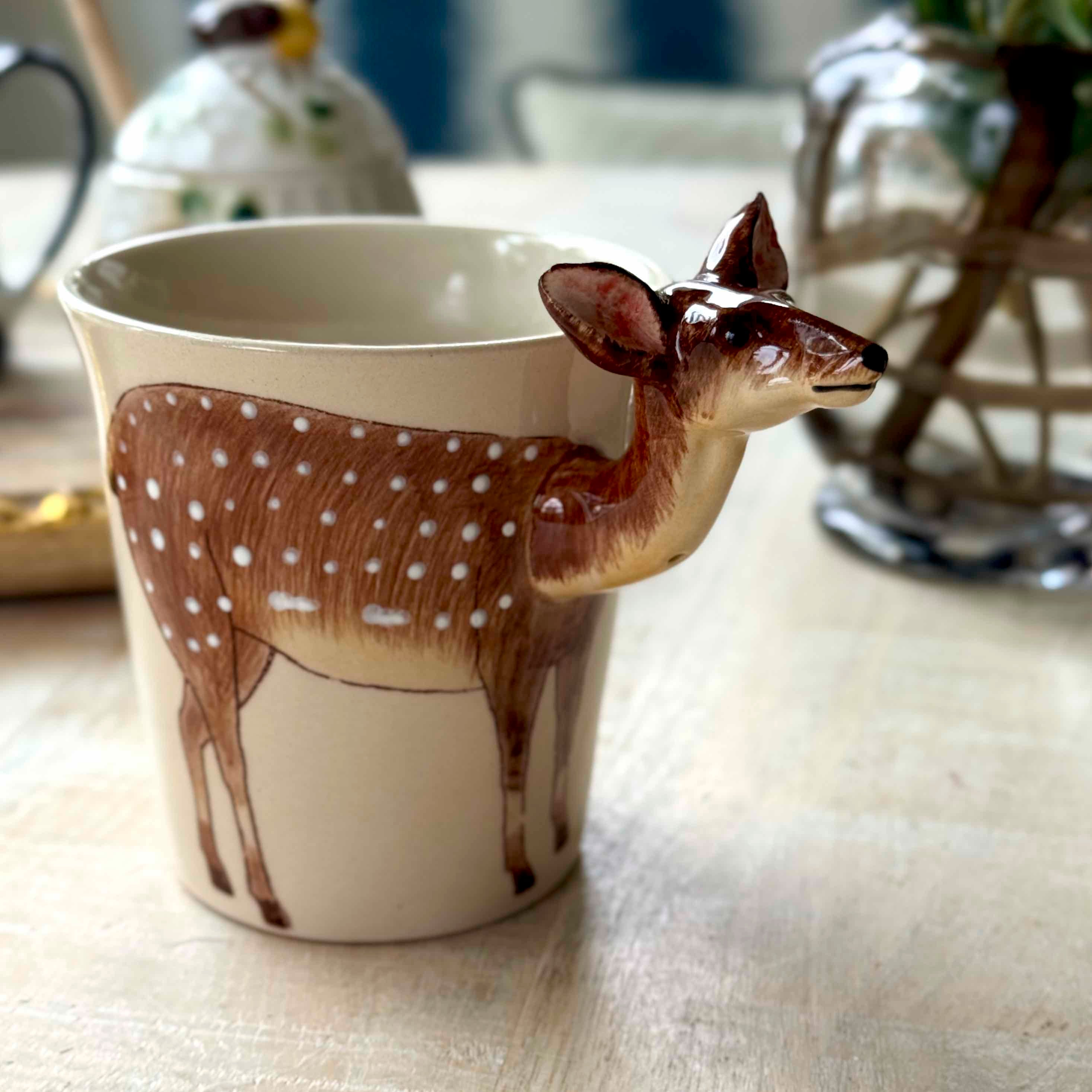 Ceramic mug with deer design on a table