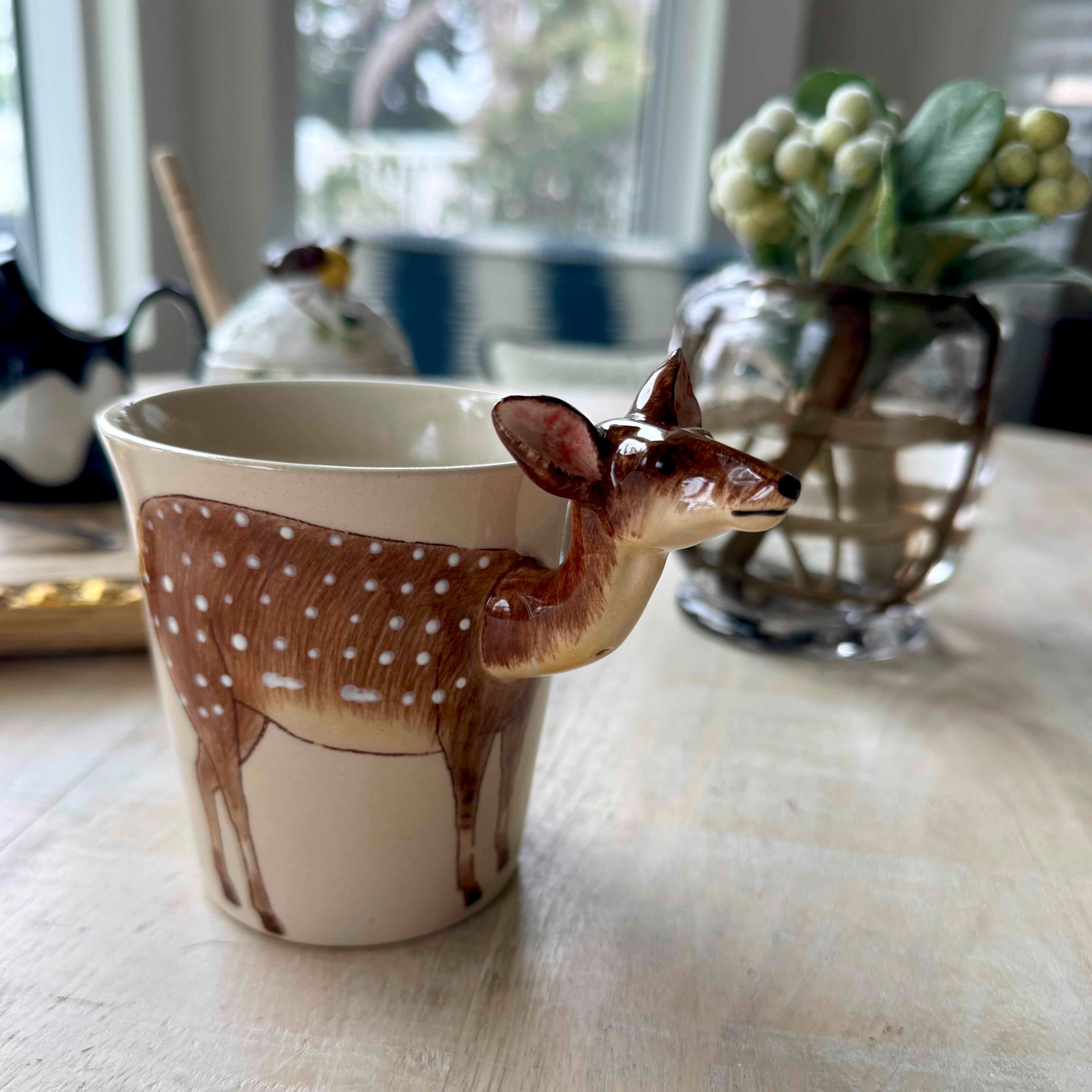 Deer-shaped mug on a table with a blurred background