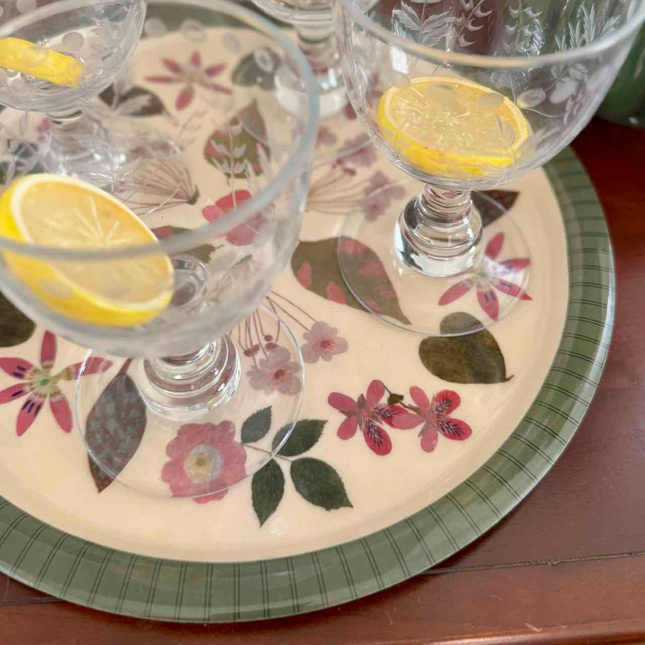 Cocktail glasses with lemon slices on a floral placemat