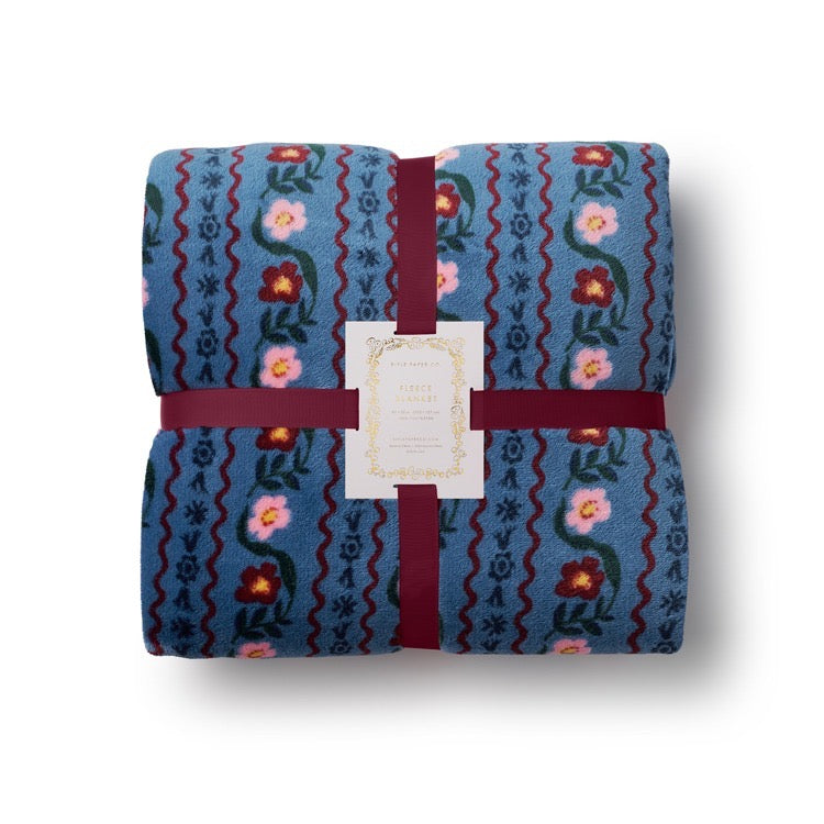 Folded fabric with floral pattern and red ribbon on a white background
