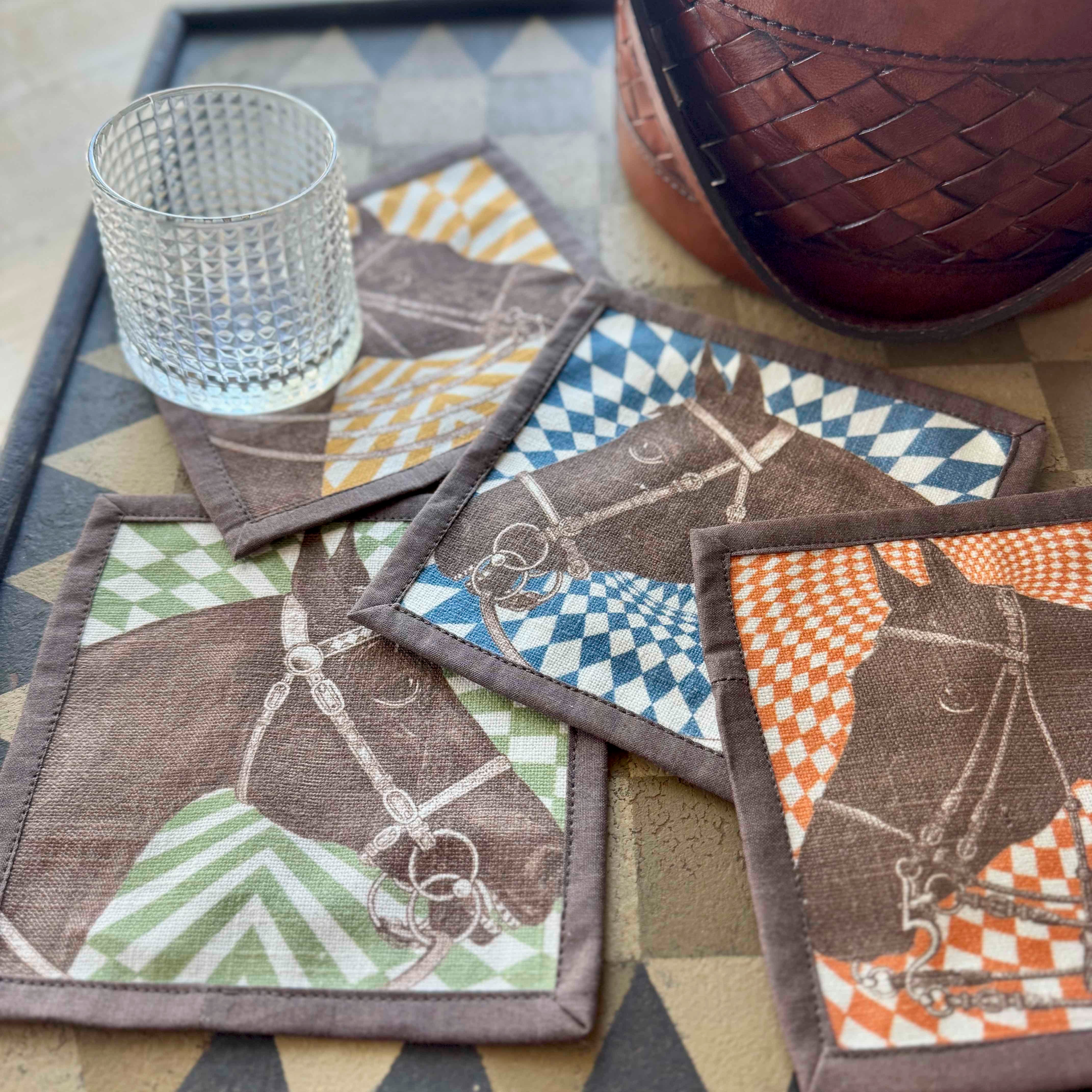 Set of coasters with horse designs on a patterned surface