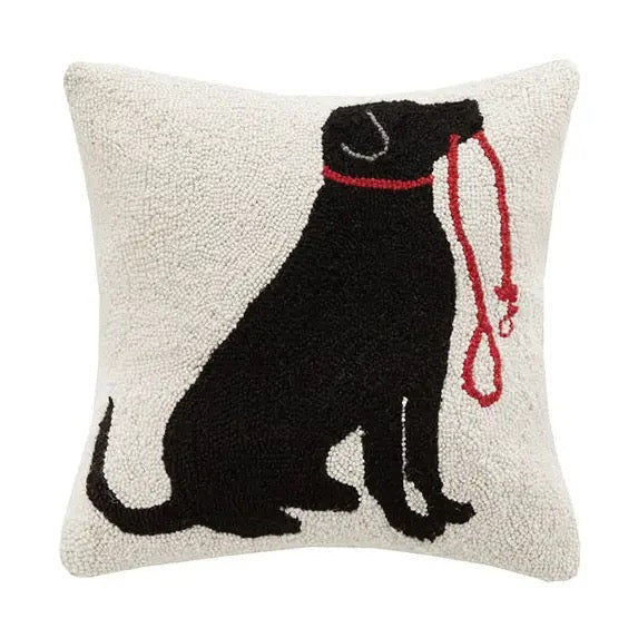 Decorative pillow with a black dog silhouette and red leash on a beige background