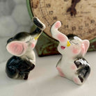 Two ceramic elephant figurines with a vintage clock in the background