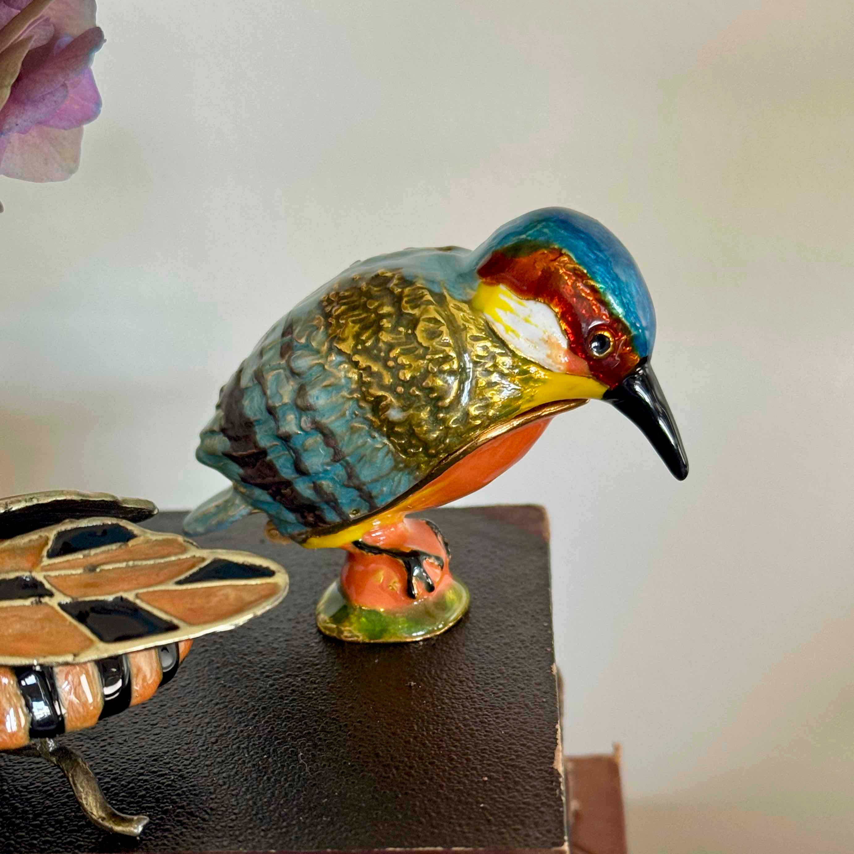 Colorful bird figurine on a stand with a blurred background
