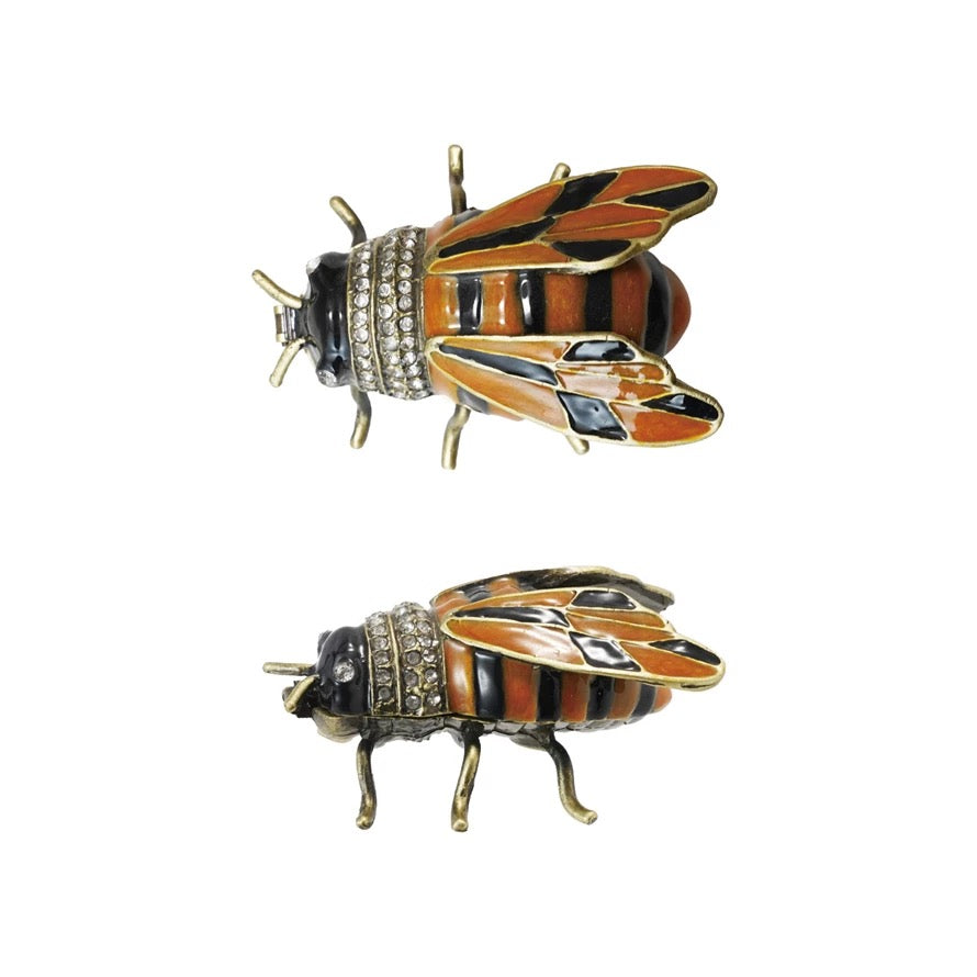 Two bee-shaped pins with rhinestone details on a white background