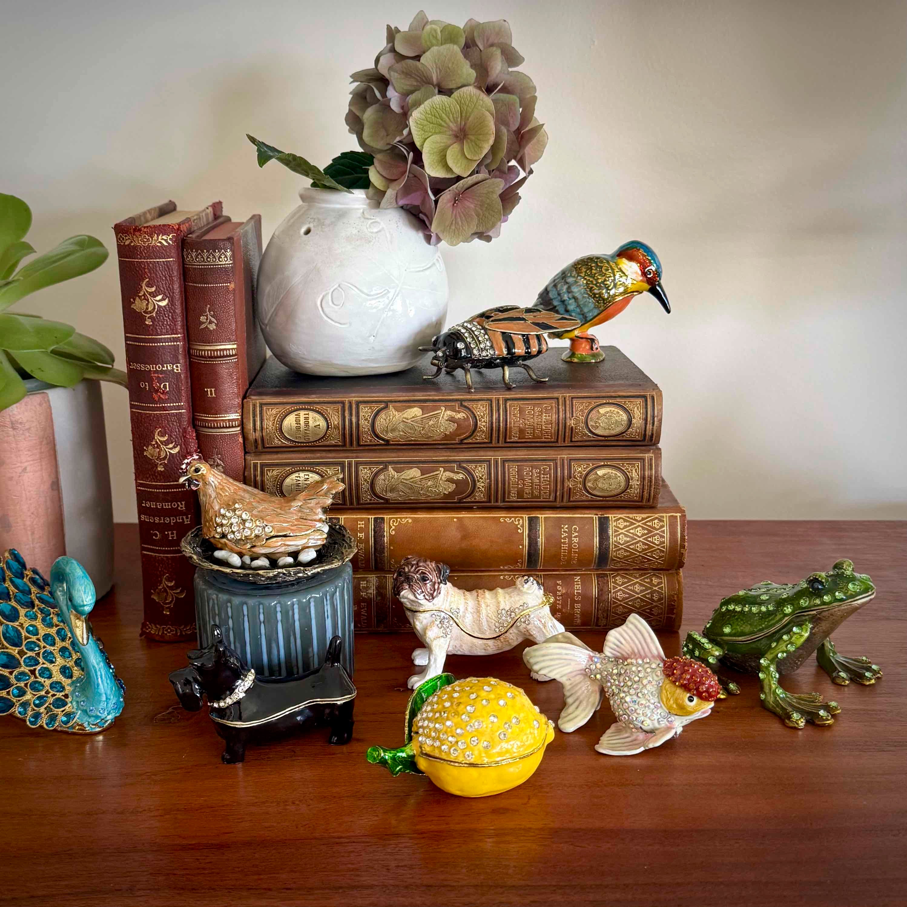 Decorative items including books, a vase with flowers, and small figurines on a wooden surface.
