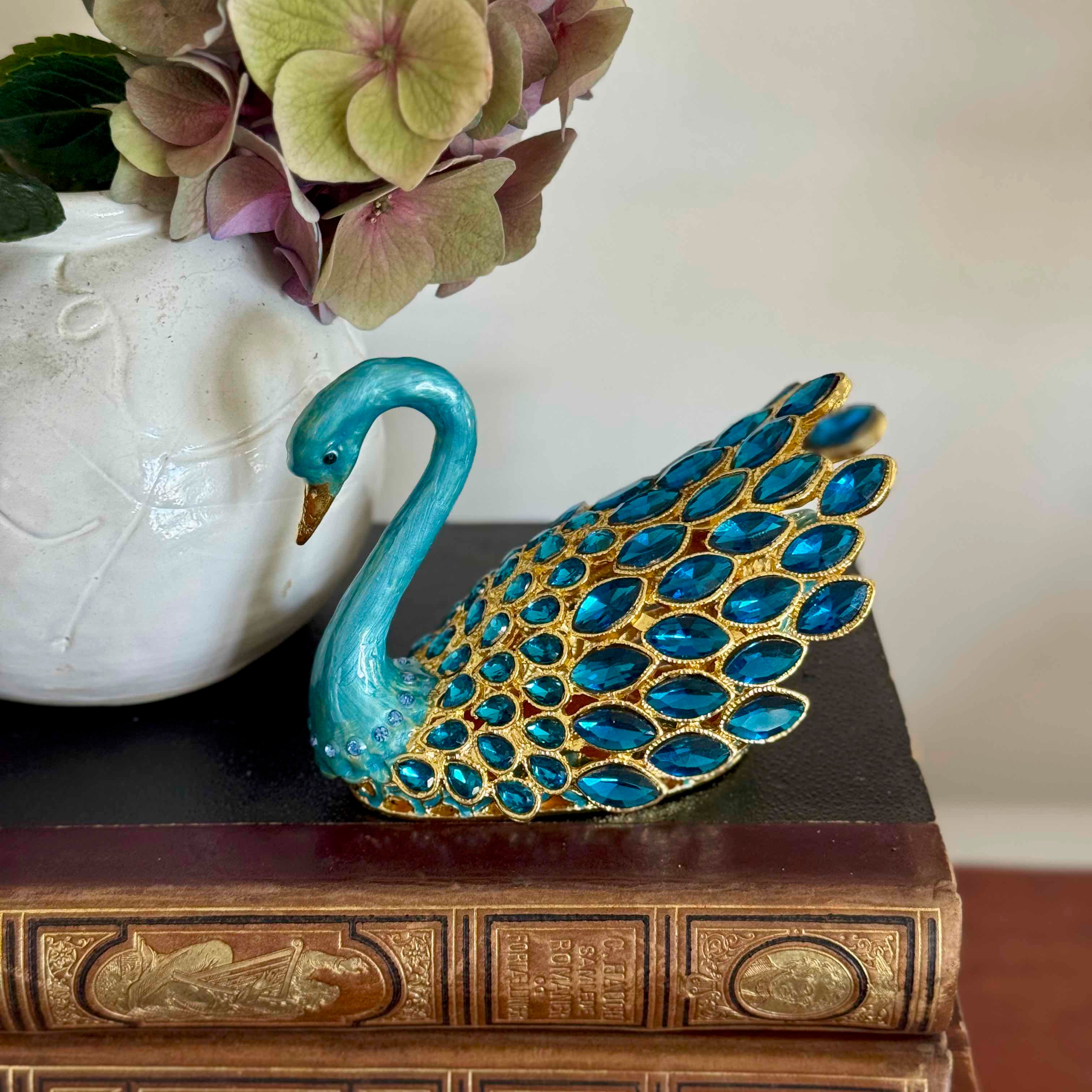 Decorative swan figurine with blue and gold details on a book