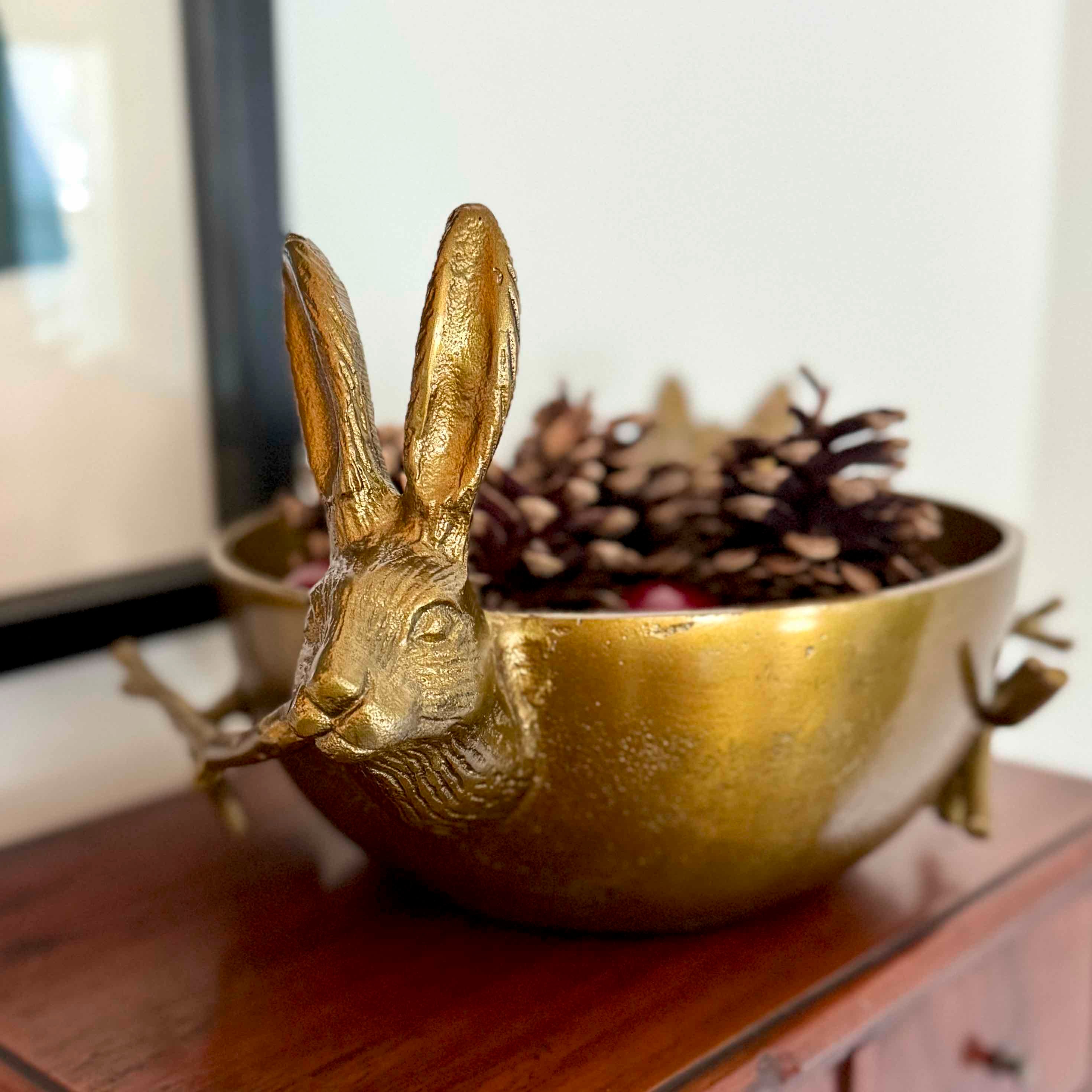 Gold rabbit-shaped bowl with decorative elements on a wooden surface